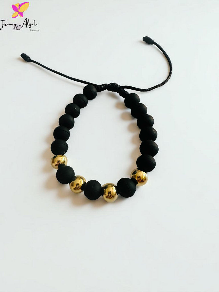 Pulsera negra con balines en oro laminado 18k